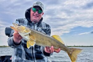 Angler holding a large fall walleye caught during a cool-weather fishing trip.