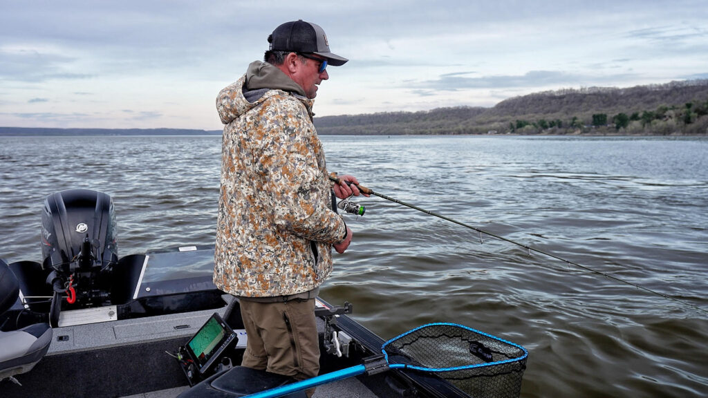 Angler standing on a boat fishing for fall walleye.
